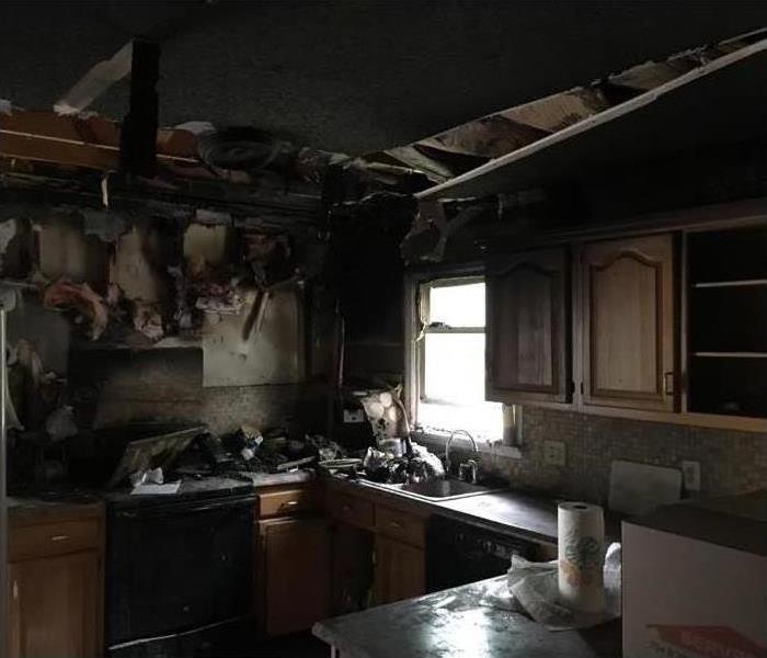 Poorly lit kitchen with significant fire damage